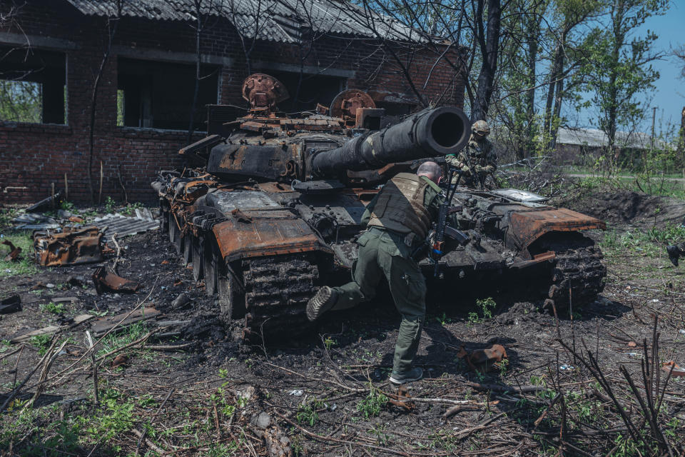Soldados ucranianos junto a un tanque ruso destruido en las afueras de Kharkiv, Ucrania, 8 de mayo de 2022 (Foto de Diego Herrera Carcedo/Agencia Anadolu v&#xed;a Getty Images)