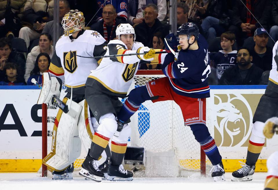 NEW YORK, NEW YORK - JANUARY 26: Zach Whitecloud #2 of the Vegas Golden Knights moves Kaapo Kakko #24 of the New York Rangers from the crease during the first period at Madison Square Garden on January 26, 2024 in New York City.