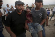 Protesters evacuate injured teen near the fence of Gaza Strip border with Israel during a protest on the beach near Beit Lahiya, northern Gaza Strip, Monday, Sept. 17, 2018. (AP Photo/Adel Hana)