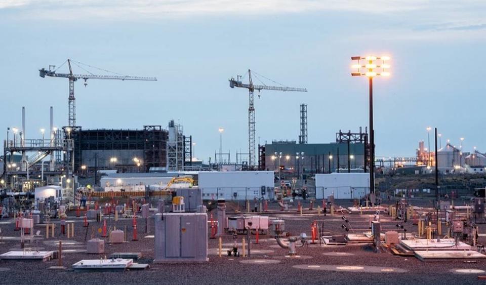 Hanford’s underground tank farms storing radioactive waste and, in the background, the $17 billion vitrification plant being built to treat the waste for disposal are shown.