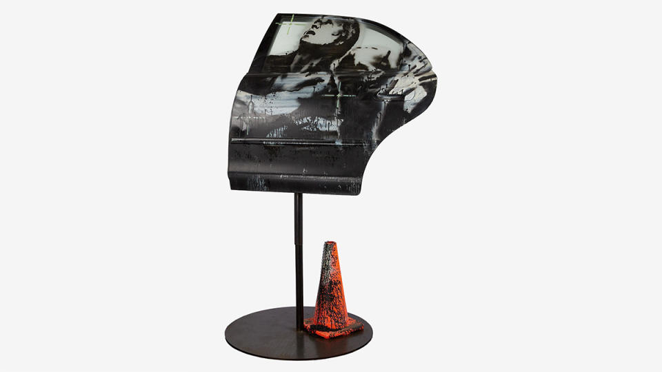 The Banksy painted car door on its custom stand and accompanying paint-splattered traffic cone.