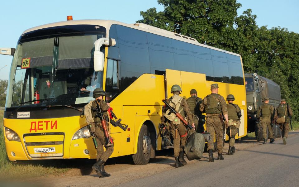 Russian service members move into positions, as part of a counter-terrorist operation declared after an armed mutiny by the Wagner mercenary group, in the Moscow region, Russia, June 24, 2023. A sign on a bus reads: "Children".