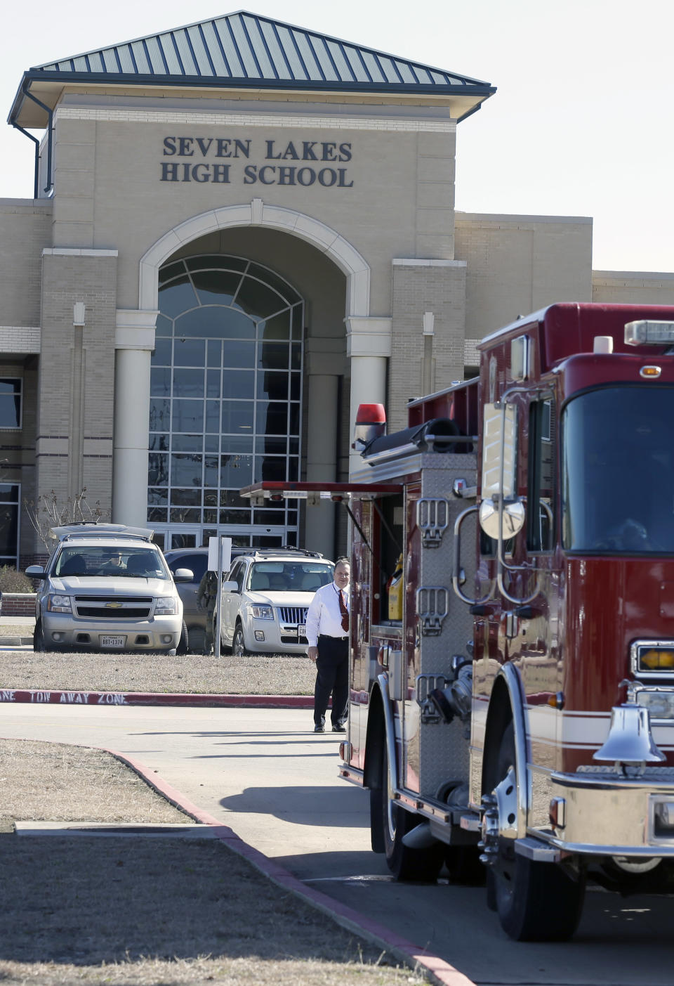 A fire truck is parked outside Seven Lakes High School Monday, Jan. 13, 2014, in Katy, Texas after bomb squad was called to the school after a potentially explosive device was found. Students were evacuated and then released for the day. (AP Photo/Pat Sullivan)