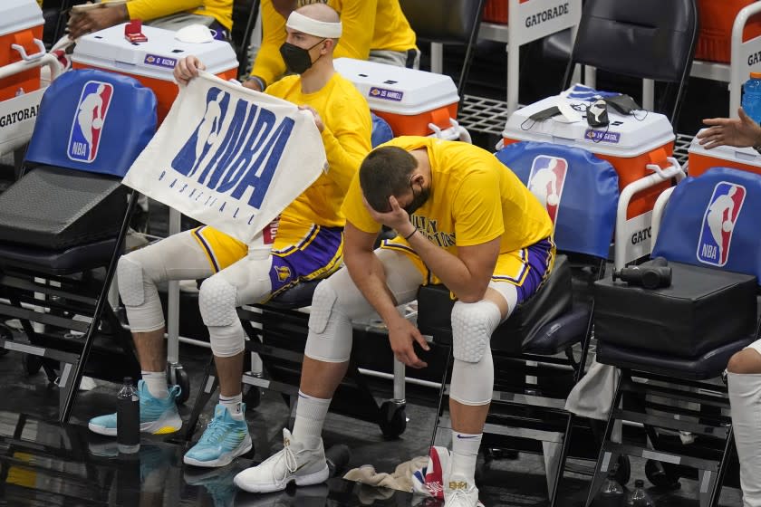 Los Angeles Lakers center Marc Gasol lowers his head while sitting next to Alex Caruso on the bench during the second half of the team's NBA basketball game against the Utah Jazz on Wednesday, Feb. 24, 2021, in Salt Lake City. (AP Photo/Rick Bowmer)