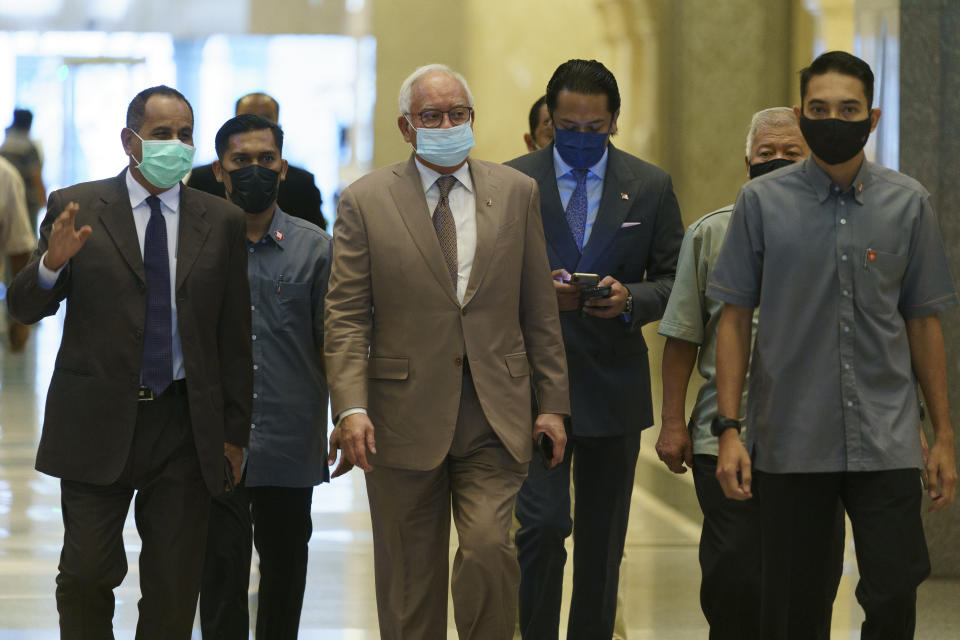 Former Malaysian Prime Minister Najib Razak, center, wearing a face mask arrives at Court of Appeal in Putrajaya, Malaysia, Monday, April 5, 2021. The court Monday began hearing an appeal by Najib to overturn his conviction and 12-year jail sentence linked to the massive looting of the 1MDB state investment fund that brought down his government in 2018. (AP Photo/Vincent Thian)