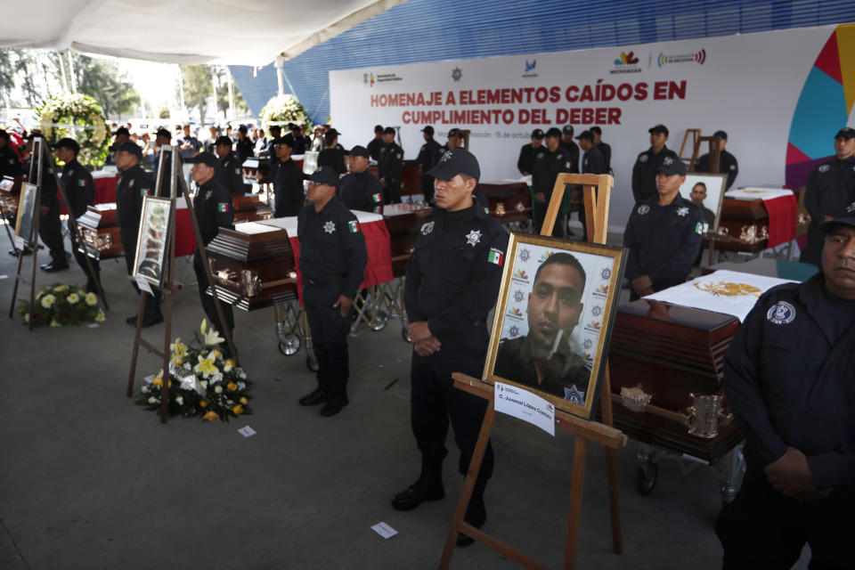 Agentes de la policía estatal de Michoacán junto a los ataúdes de sus colegas durante un funeral en la sede de la Secretaría de Seguridad Pública, en Morelia, México, el martes 15 de octubre de 2019. (AP Foto/Marco Ugarte)