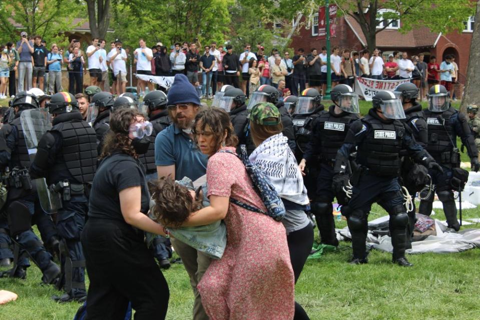 A medic and three demonstrators help a protester to the ground while Indiana State Police clear the encampment on April 27. There was a rotating crew of medics at the encampment. <span class="copyright">Taylor Satoski for The Indiana Daily Student</span>