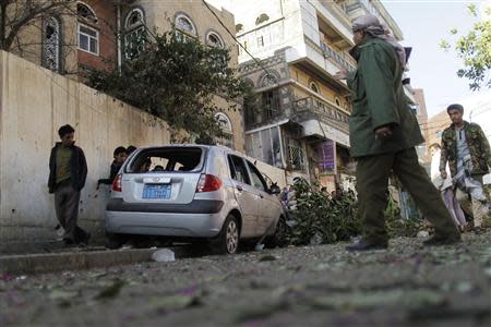 A police trooper (2nd R) guards the site of an explosion in Sanaa February 3, 2014. REUTERS/Khaled Abdullah