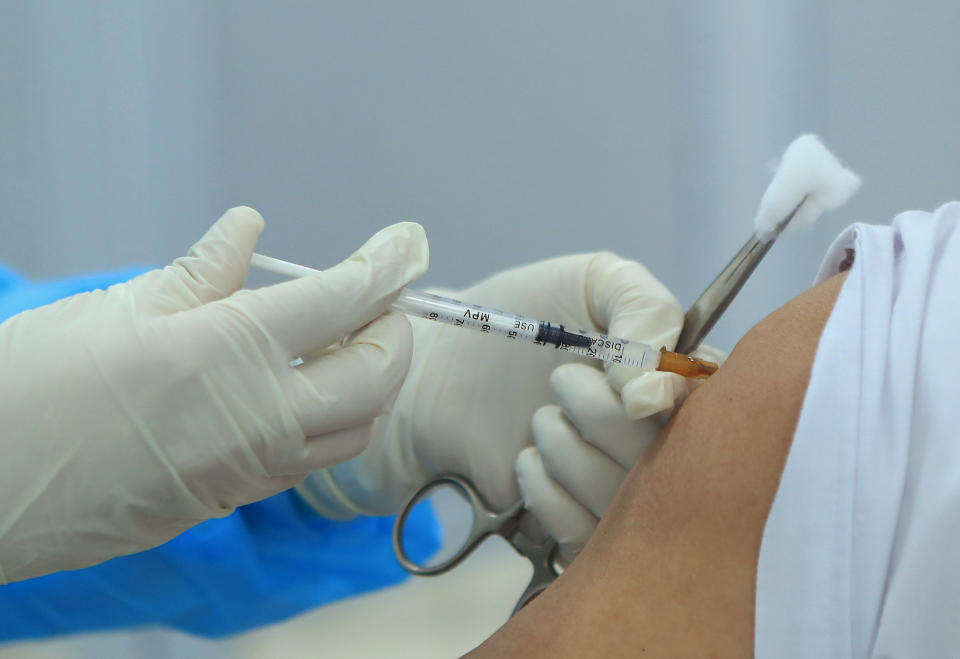 A health worker injects a doctor with a dose of AstraZeneca COVID-19 vaccine at Hospital for Tropical Diseases in Hanoi, Vietnam Monday, March 8, 2021. Vietnam has started the vaccination campaign with a hope to inoculate half of the population of 96 millions against COVID-19 by the end of the year. (AP Photo/Hau Dinh)