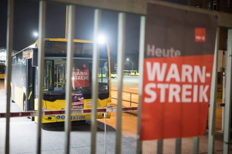 A sign reading "Warning strike" hangs at a BVG bus depot in Müllerstrasse. Over 80 cities were called to go on a warning strike as part of the nationwide wage dispute in regional negotiations by the Verdi trade union. Sebastian Christoph Gollnow/dpa