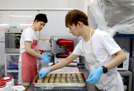 Leong Guzifer (L), 30, and Ting Tseyen, 27, prepare to bake scones in the kitchen of Shin's Jam & Pastry Collection, which they run together, in Kaohsiung, Taiwan, November 17, 2018. REUTERS/Ann Wang