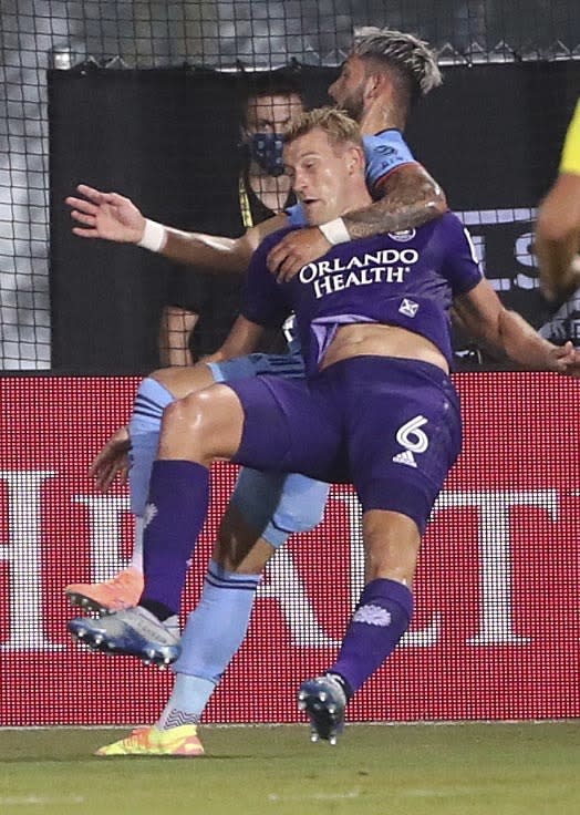 New York City FC's Valentin Castellanos, rear, pulls down Orlando City's Robin Jansson (6) during the MLS is Back tournament soccer match, Tuesday, July 14, 2020, in Lake Buena Vista, Fla. Castellanos received a yellow card for the rough play. (Stephen M. Dowell/Orlando Sentinel via AP)