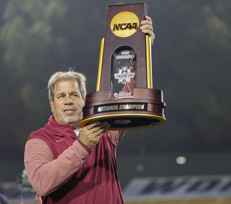 Florida State Seminoles head coach Mark Krikorian holds up the championship trophy for photos. The Florida State Seminoles defeated the Brigham Young Cougars 4-3 with penalty kicks after two scoreless overtimes during the NCAA Championship game in Santa Clara, California on Monday, Dec. 6, 2021.