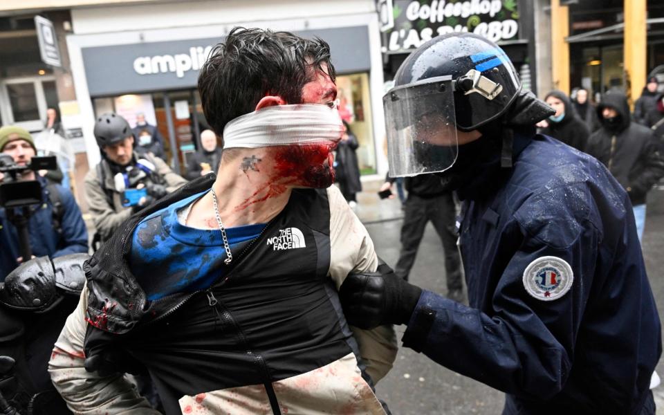 Riot police officers detain a person during a rally organised by fishermen in Rennes - DAMIEN MEYER/AFP via Getty Images