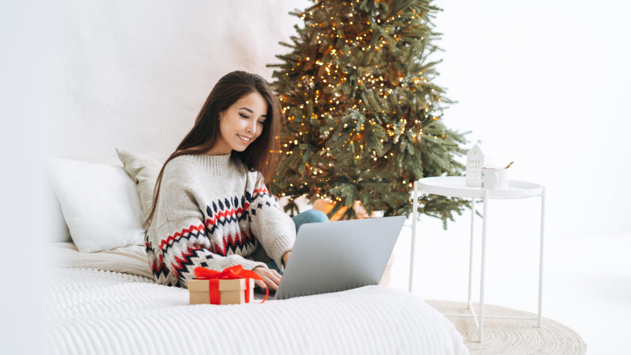  Woman using a laptop at Christmas. 
