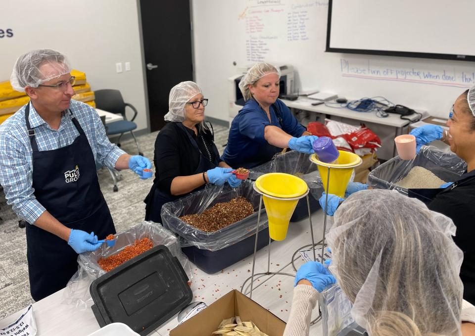 Clockwise: PulteGroup employees Sean Strickler, Denise Paxson, Terry Bradberry, Vania Jenkins and Nicole Tumminia pack rice and beans to be donated to Salvation Army Ocala and Feeding Tampa Bay. More than 60 employee volunteers at two locations and packed more than 20,000 meals.