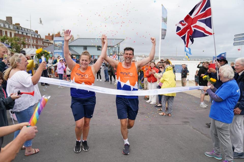 Charlotte Nichols and Stuart Bates finishing their marathon at Weymouth Beach (Andrew Matthews/PA) (PA Wire)