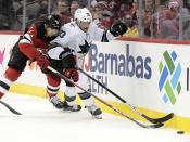 San Jose Sharks left wing Matt Nieto (83) and New Jersey Devils defenseman Jonas Siegenthaler (71) battle for control of the puck during the second period of an NHL hockey game Tuesday, Nov. 30, 2021, in Newark, N.J. (AP Photo/Bill Kostroun)