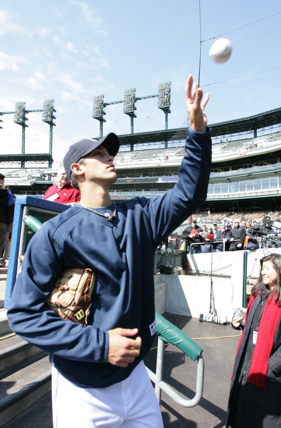 Detroit Tigers rookie pitcher Rick Porcello snags a fan's ball to autograph as he gets ready to leave the dugout after their batting practice before the Tigers' home opener against the Texas Rangers in Detroit on April 10, 2009.