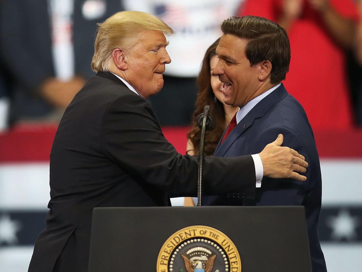 Then-President Donald Trump greets then-Florida Republican gubernatorial candidate Ron DeSantis during a campaign rally at the Hertz Arena on October 31, 2018 in Estero, Florida.