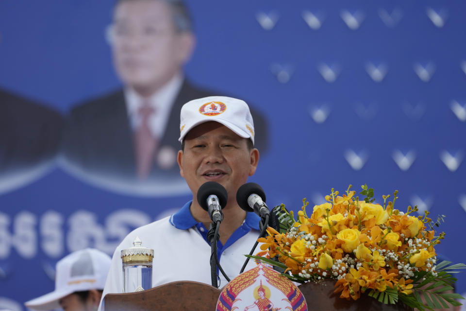 Hun Manet, son of Cambodia Prime Minister Hun Sen, also army chief, delivers a speech in front of his father portrait poster before leading a procession as marking the end of an election campaign of Cambodian People's Party, in Phnom Penh, Cambodia, on July 21, 2023. Cambodian King Norodom Sihamoni on Monday, Aug. 7, formally endorsed army chief Hun Manet to succeed his father and long-ruling Prime Minister Hun Sen as the nation's leader later this month after their party sealed victory in a one-sided election last month. (AP Photo/Heng Sinith)