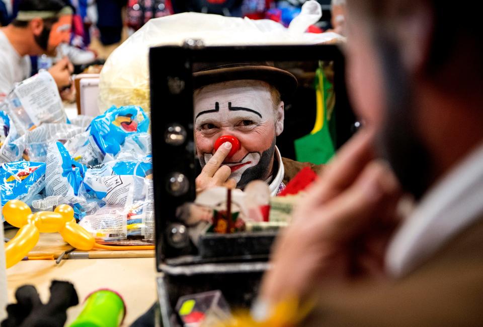 Hadi Funsters guest clown Mike "Squeeky" Kapshandy of Springfield, Ill., applies pressure to secure his clown nose while he prepares for the 86th Hadi Shrine Circus at Ford Center Friday morning, Nov. 29, 2019. 