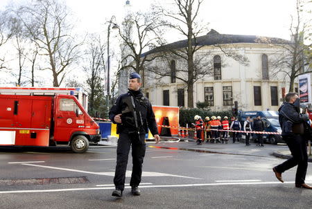 A Belgian police officer and firefighters stand outside the Grand Mosque in Brussels, Belgium November 26, 2015. REUTERS/Francois Lenoir