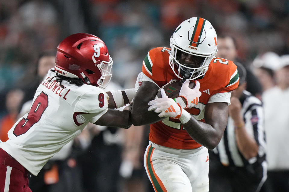 Miami (Ohio) defensive back Jeremiah Caldwell (9) pushes Miami running back Mark Fletcher Jr. out of bounds during the first half of an NCAA college football game, Friday, Sept. 1, 2023, in Miami Gardens, Fla. (AP Photo/Wilfredo Lee)