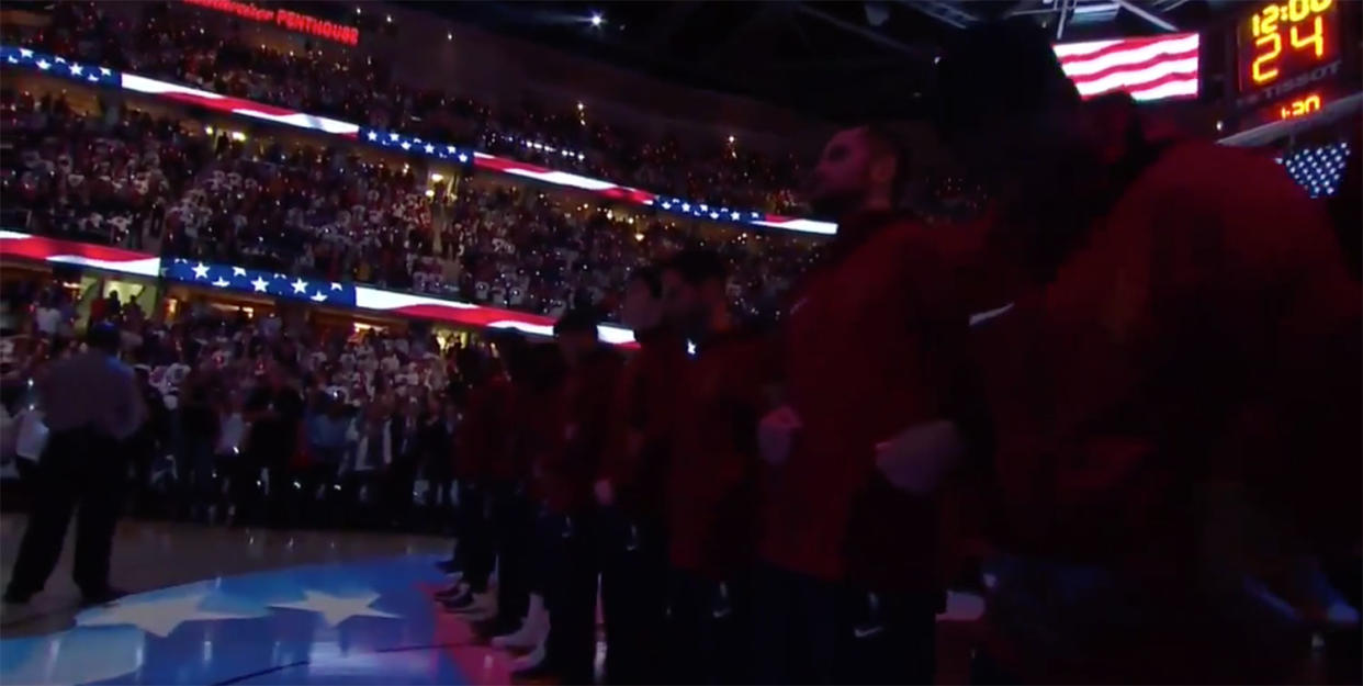 Members of the Cleveland Cavaliers stand and lock arms during the national anthem before their season opener against the Boston Celtics. (Screencap via Sports Illustrated)