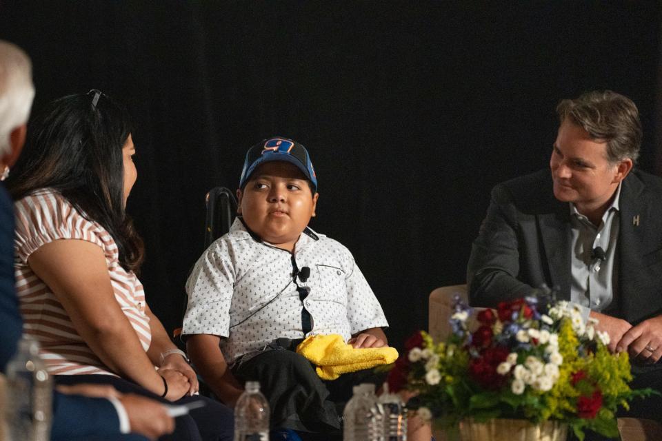 Daniel Sanchez (center, cancer patient) answers questions at the NASCAR Championship Ignition Luncheon, August 30, 2022, at the Arizona Biltmore, 2400 E Missouri Ave., Phoenix, Arizona. Looking on is his mom, Janeth Sosa (left) and four-time NASCAR Cup Series champion Jeff Gordon (right).