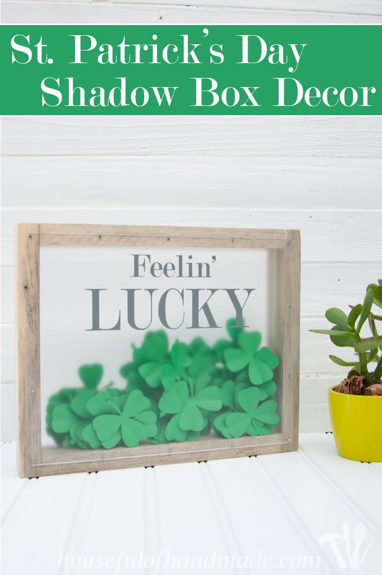 shadow box that reads feelin' lucky filled with green paper clovers