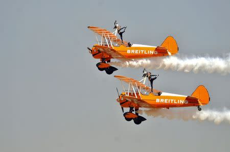 Members of the Breitling Wingwalkers perform during the inauguration ceremony of the "Aero India 2015" air show at Yelahanka air base in the southern Indian city of Bengaluru February 18, 2015. REUTERS/Abhishek N. Chinnappa