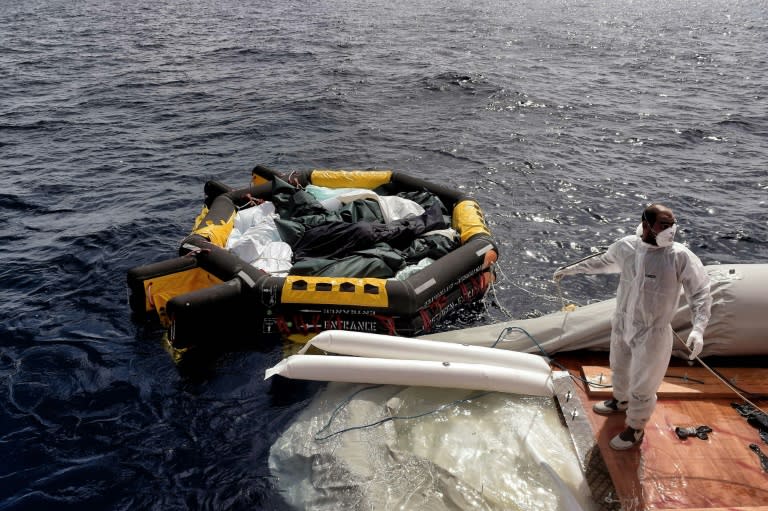 A member of the Spanish NGO Proactiva Open Arms stands near a life boat carrying the bodies of 29 refugees and migrants, who died on a rubber boat north of Libya while crossing the Mediterranean Sea