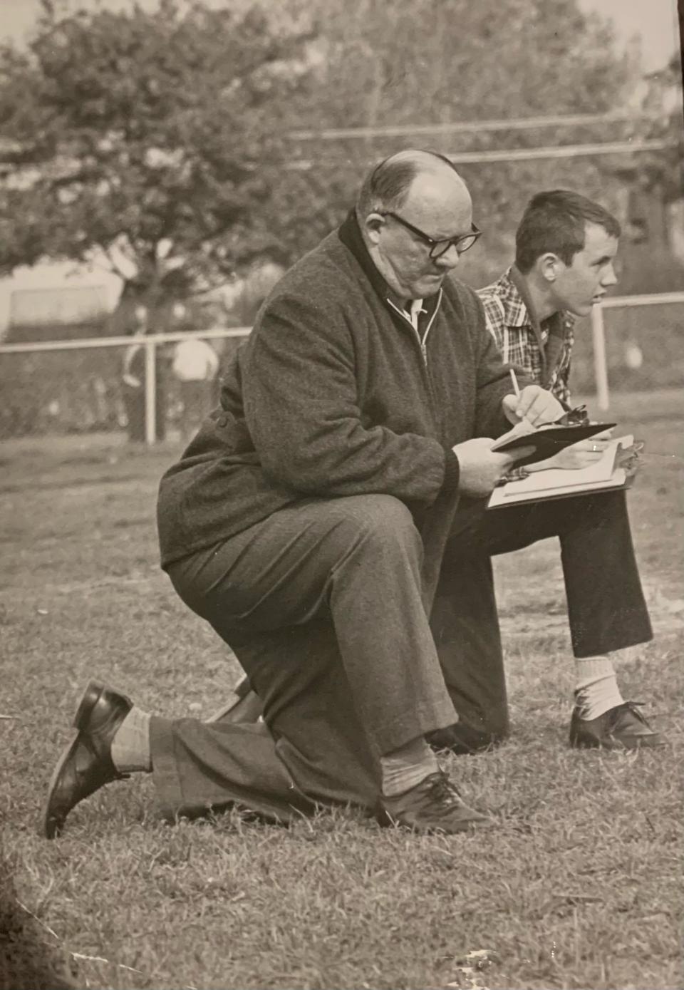 A young John Rowe (R) on the sidelines of a game with his dad Walter "Hawk" Rowe