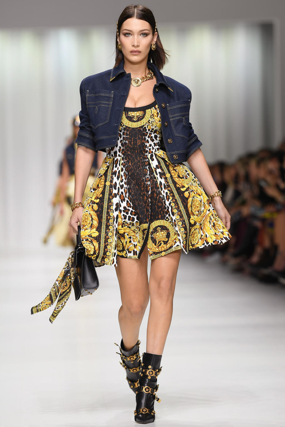 <p>Bella rocked a cropped jean jacket over her printed mini for Versace.</p>