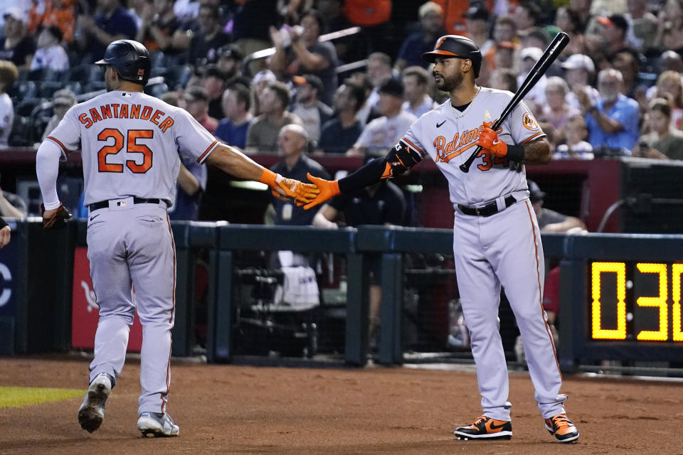 Baltimore Orioles' Anthony Santander (25) celebrates his run scored against the Arizona Diamondbacks with teammate Aaron Hicks during the first inning of a baseball game, Sunday, Sept. 3, 2023, in Phoenix. (AP Photo/Ross D. Franklin)