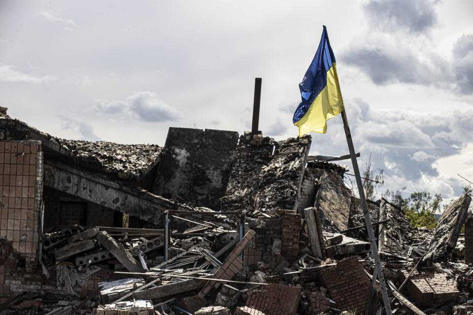 DOLINA, DONETSK, UKRAINE - SEPTEMBER 24: Ukrainian flag waves in a residential area heavily damaged in the village of Dolyna in Donetsk Oblast, Ukraine after the withdrawal of Russian troops on September 24, 2022. Many houses and St. George's Monastery were destroyed in the Russian attacks. Ukraine said on Saturday that its soldiers were entering the city of Lyman in the eastern region of Donetsk, which Russia had annexed a day earlier. (Photo by Metin Aktas/Anadolu Agency via Getty Images)