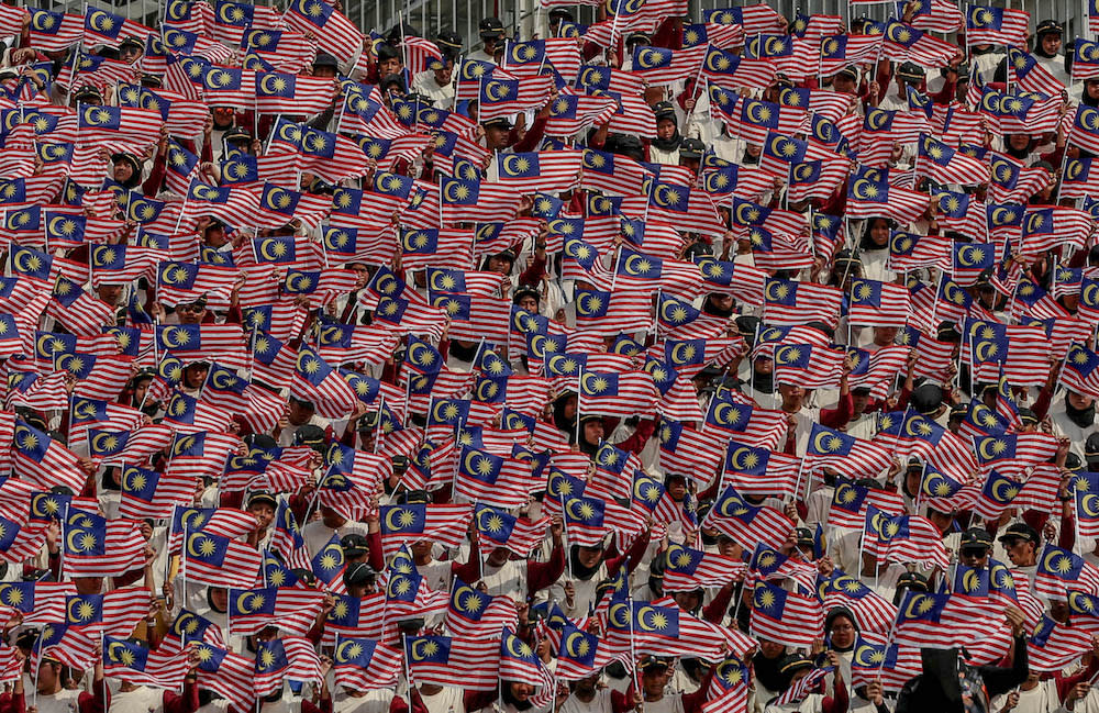 Participants wave the Malaysian flag during a National Day rehearsal in Putrajaya August 29, 2019. — Picture by Firdaus Latif