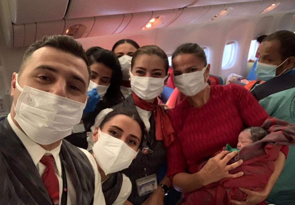 Turkish Airlines crew members pose with newly born Afghan baby girl Havva, which translates as Eve in English, during a flight between Dubai and Birmingham, U.K., Saturday, Aug. 28, 2021. An evacuation flight from Afghanistan landed in the U.K. with an extra passenger on Saturday after cabin crew delivered a baby girl mid-air, Turkish media reported.(Turkish Airlines via AP)