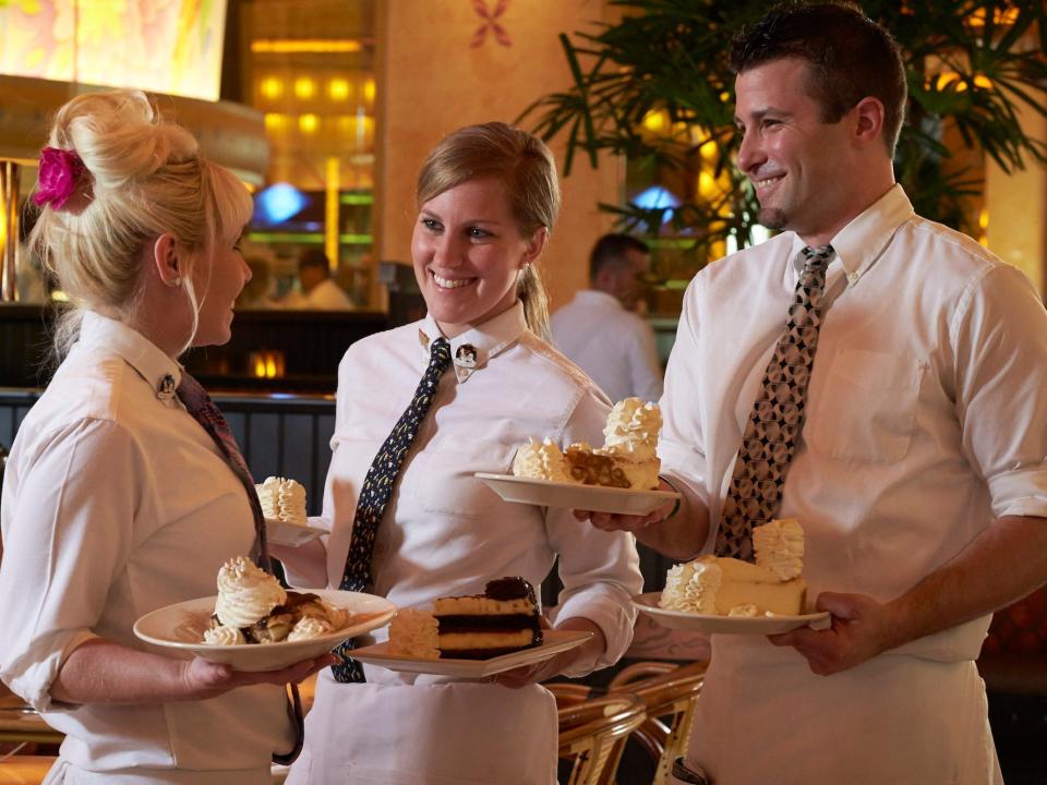 Cheesecake Factory servers with cakes