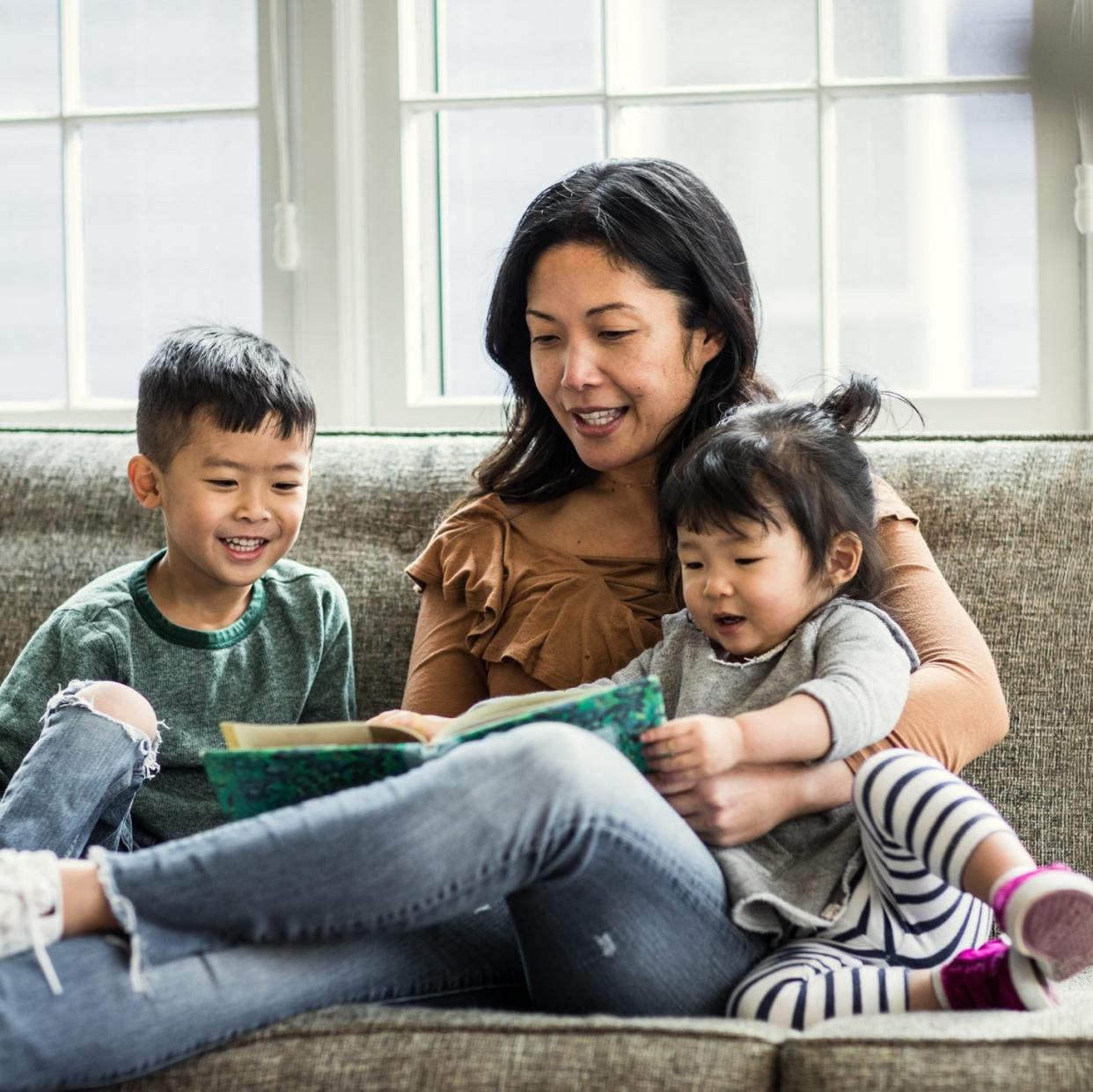 Mother reading to kids on couch