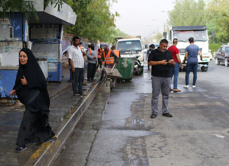 A woman walks past the site of a suicide attack in the predominantly Shi'ite Shula district, in northwest Baghdad, Iraq May 24, 2018. REUTERS/Thaier Al-Sudani