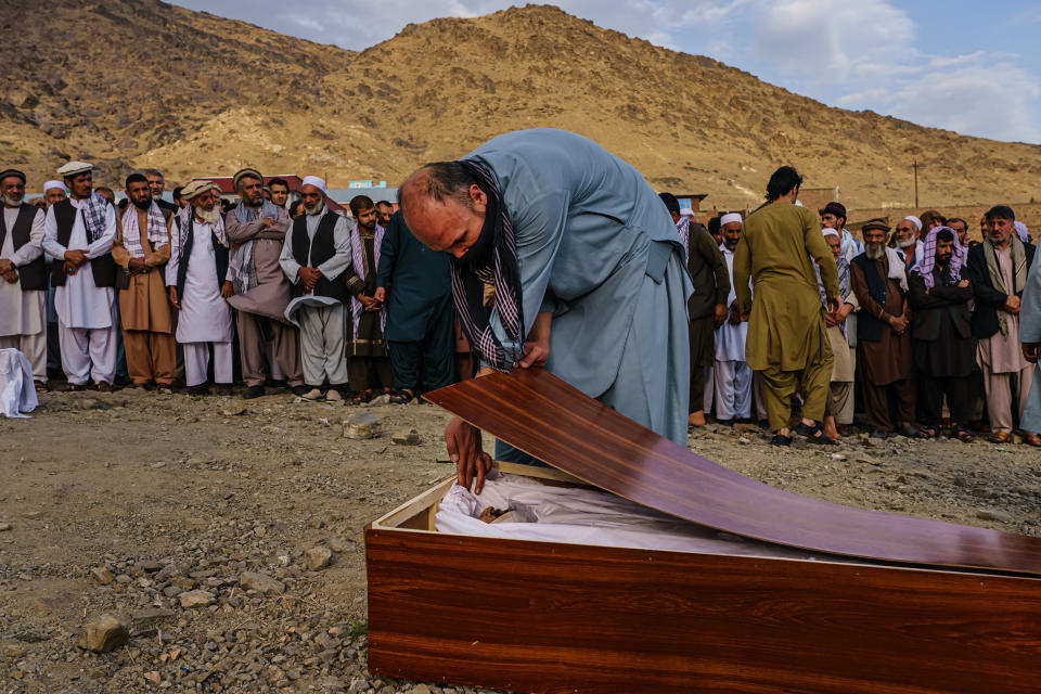 A man bids farewell to Zamarai Ahmadi in his casket during a mass funeral in Kabul on Aug. 30, 2021.<span class="copyright">Marcus Yam—Los Angeles Times/Getty Images</span>