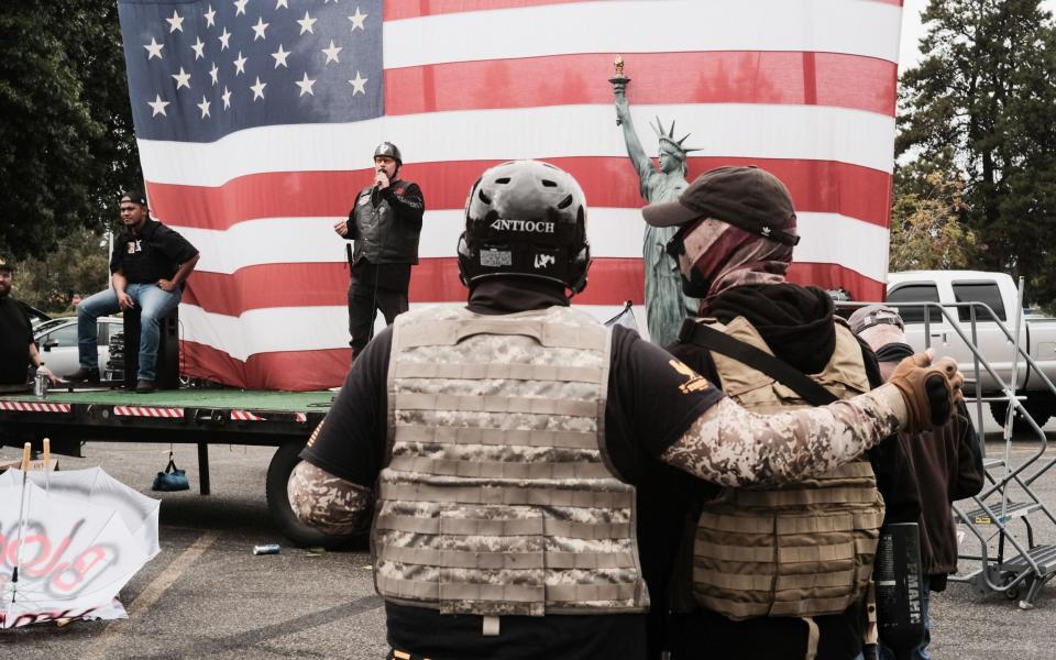 Two Proud Boys embrace during a speech at a Far Right rally in Portland - Shutterstock 