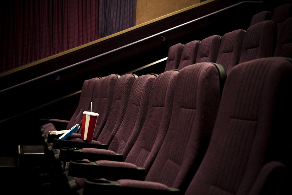 Row of empty theater seats with a single spilled drink and snack on the floor
