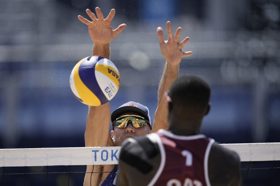 Philip Dalhausser, left, of the United States, trees to block the shot of Cherif Younousse, of Qatar, during a men's beach volleyball match at the 2020 Summer Olympics, Sunday, Aug. 1, 2021, in Tokyo, Japan. (AP Photo/Felipe Dana)