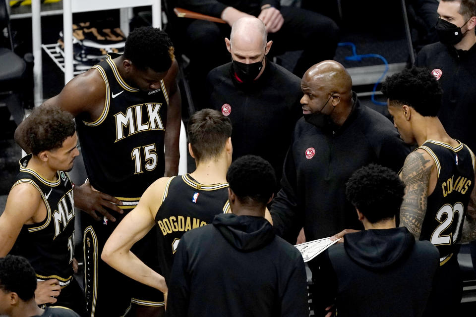 Atlanta Hawks head coach Nate McMillan, right, speaks to his player before an NBA basketball game against the Phoenix Suns, Wednesday, May 5, 2021, in Atlanta. (AP Photo/John Bazemore)