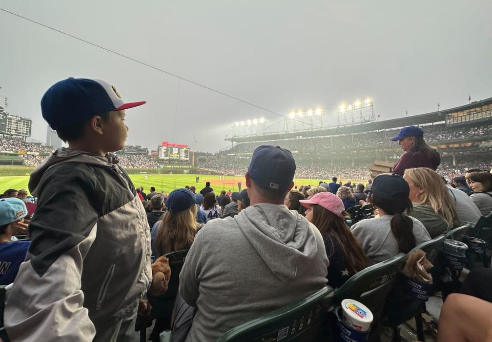 Fans watch a baseball game between the Philadelphia Phillies and Chicago Cubs as smoke from Canada's ongoing wildfires shrouds Wrigley Field in a haze, in Chicago, Tuesday, June 27, 2023. (AP Photo/Kim Johnson)