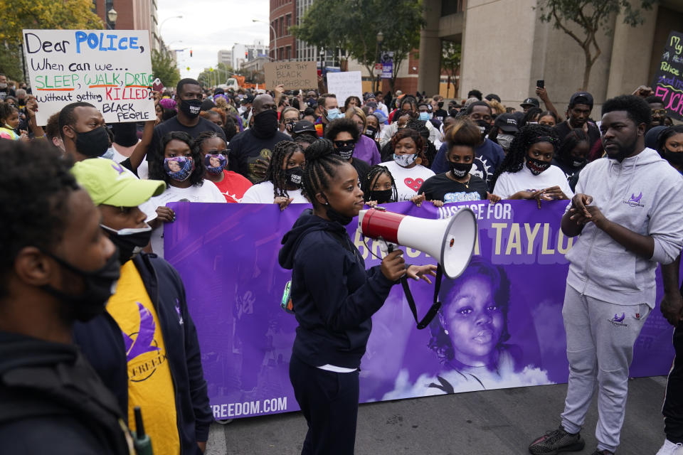 A woman speaks to gathered protesters, Friday, Sept. 25, 2020, in Louisville. Breonna Taylor's family demanded Friday that Kentucky authorities release all body camera footage, police files and the transcripts of the grand jury hearings that led to no charges against police officers who killed the Black woman during a March drug raid at her apartment. (AP Photo/Darron Cummings)