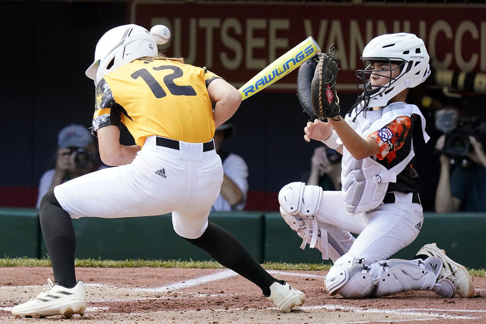 Stella Weaver (12), de Nolensville, Tennessee, se agacha al recibir un pelotazo durante la Serie Mundial de Pequeñas Ligas en South Williamsport, Pennsylvania, el viernes 18 de agosto de 2023 (AP Foto/Tom E. Puskar)